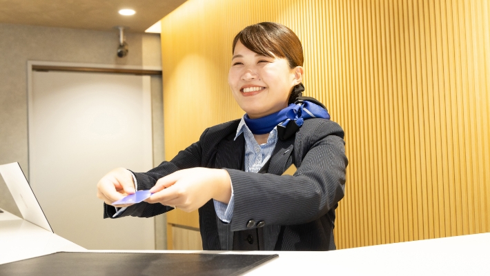 お客様にカードキーをお渡しする石田さん