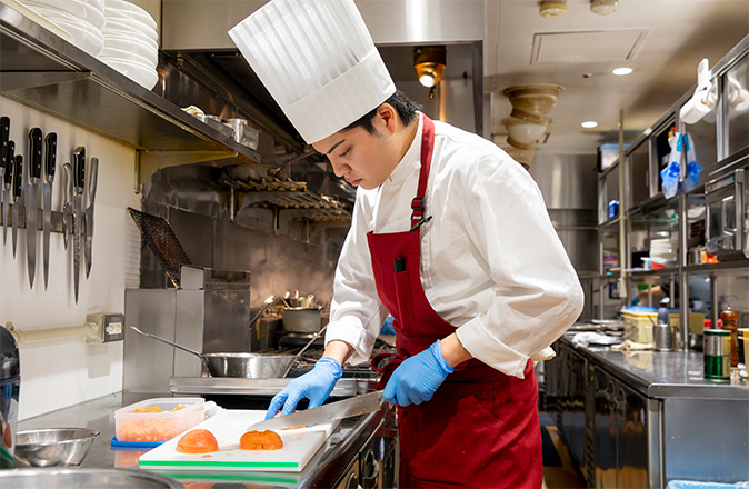 フルーツをカットしている調理・製菓部門スタッフのイメージ