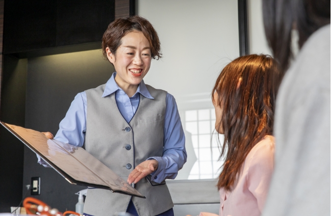 お客様にメニューを紹介する料飲部門スタッフのイメージ